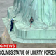Image for article titled A Black Woman in Handcuffs For Climbing The Statue of Liberty on Independence Day is a Perfect Metaphor For America